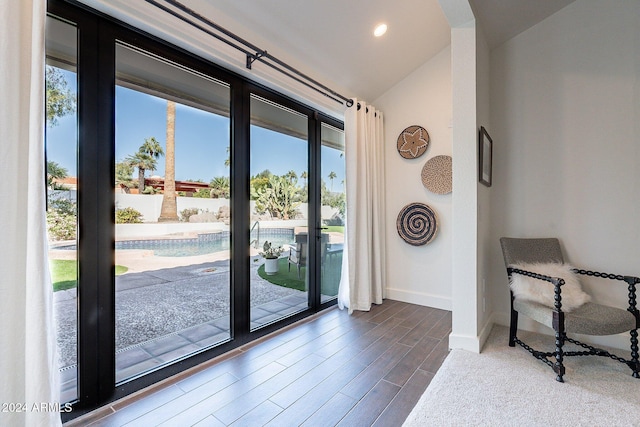 doorway to outside featuring vaulted ceiling, dark wood-style flooring, recessed lighting, and baseboards