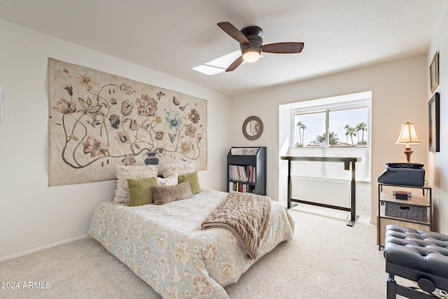 bedroom featuring light colored carpet, ceiling fan, and baseboards