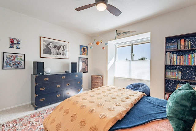 bedroom with light colored carpet, ceiling fan, and baseboards