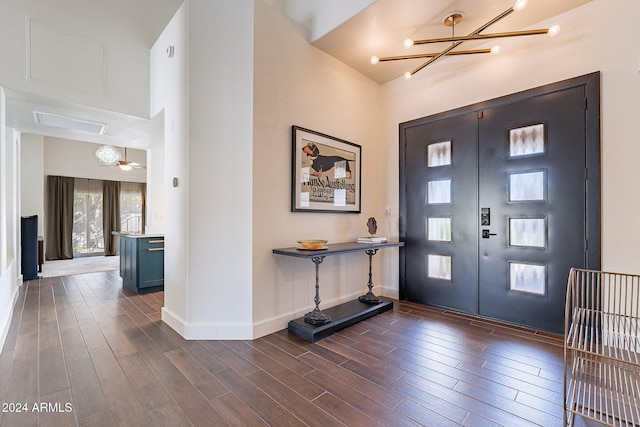 foyer entrance with dark wood-style floors, baseboards, an inviting chandelier, and french doors