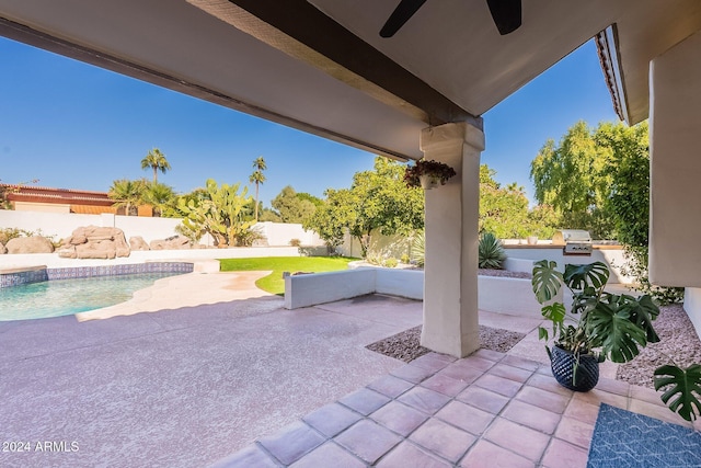 view of patio / terrace featuring a fenced backyard, a fenced in pool, an outdoor kitchen, and a ceiling fan