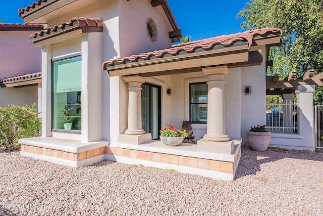 back of property with a tile roof and stucco siding