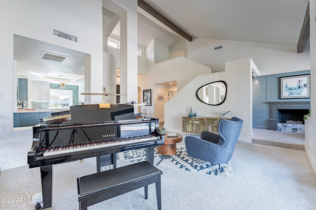 sitting room with high vaulted ceiling, visible vents, a fireplace with raised hearth, and beamed ceiling