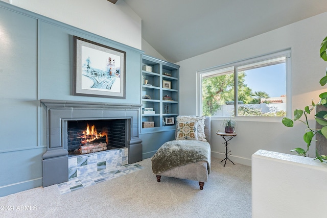 living area featuring lofted ceiling, carpet floors, a tile fireplace, and baseboards