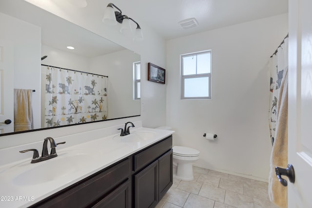 bathroom featuring tile patterned floors, vanity, toilet, and walk in shower