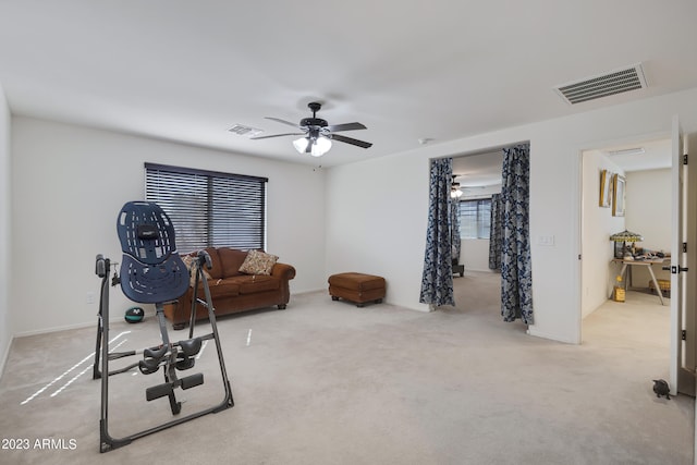 workout room featuring light carpet and ceiling fan