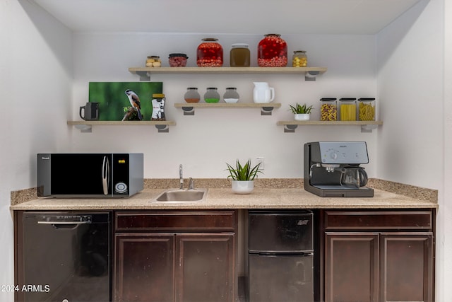 bar featuring dark brown cabinetry, sink, and black appliances