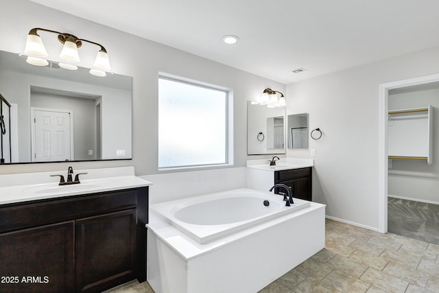 bathroom featuring a washtub and vanity