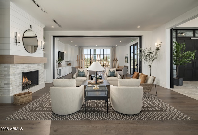 living room with wood-type flooring and a brick fireplace