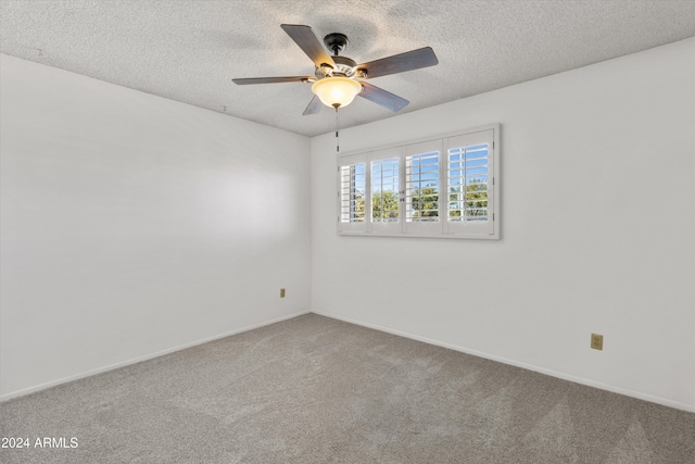 empty room featuring ceiling fan, carpet flooring, and a textured ceiling