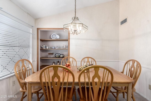 dining room featuring vaulted ceiling, visible vents, and an inviting chandelier