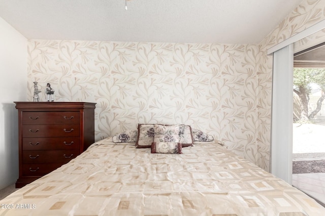 bedroom featuring access to exterior and wallpapered walls