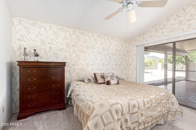 bedroom with access to exterior, lofted ceiling, light carpet, ceiling fan, and wallpapered walls