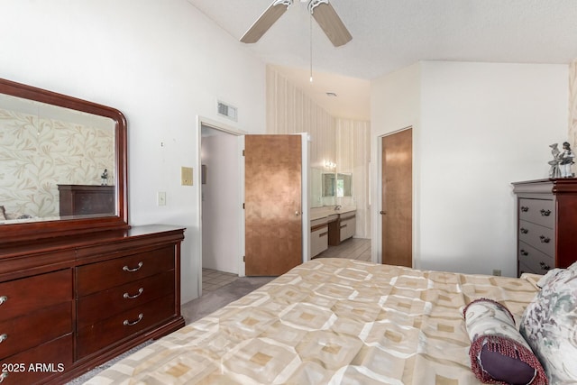 bedroom with high vaulted ceiling, ensuite bath, visible vents, and ceiling fan