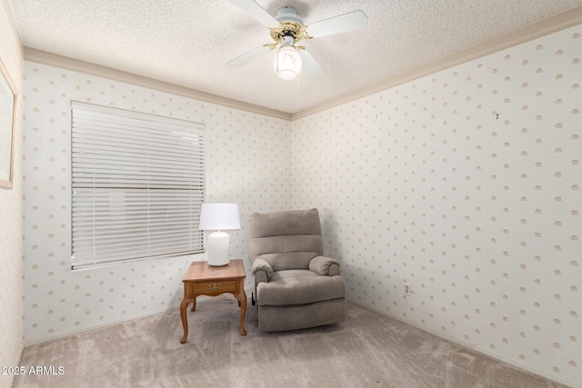 living area with carpet flooring, ceiling fan, a textured ceiling, and wallpapered walls