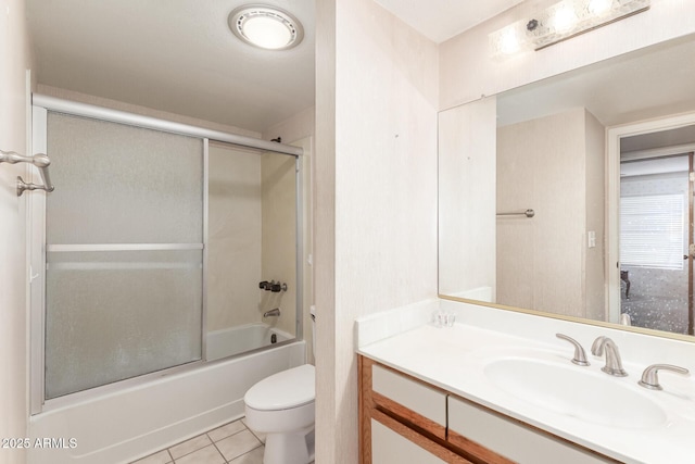 full bathroom featuring toilet, tile patterned flooring, bath / shower combo with glass door, and vanity