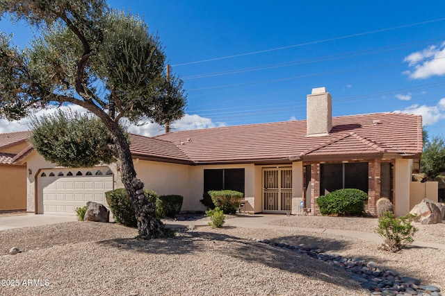 single story home featuring a garage, concrete driveway, a chimney, a tiled roof, and stucco siding