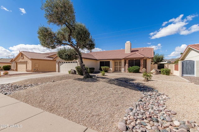 ranch-style home featuring concrete driveway, a chimney, a tiled roof, an attached garage, and stucco siding