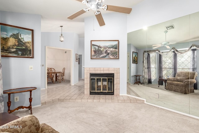 living room featuring visible vents, a ceiling fan, carpet flooring, a fireplace, and high vaulted ceiling