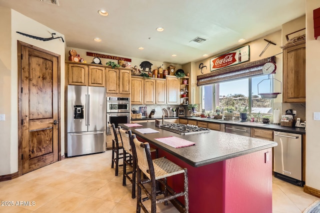 kitchen with dark countertops, stainless steel appliances, a kitchen island with sink, visible vents, and decorative backsplash