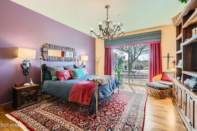 bedroom featuring access to exterior, a chandelier, and light wood-type flooring