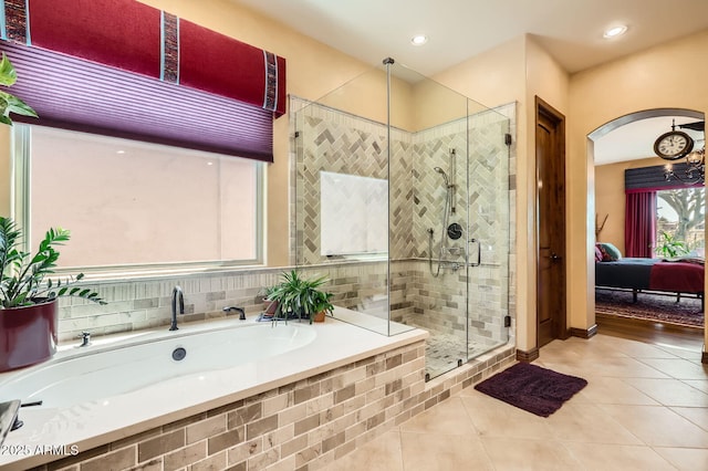 ensuite bathroom featuring a garden tub, connected bathroom, a stall shower, and tile patterned flooring