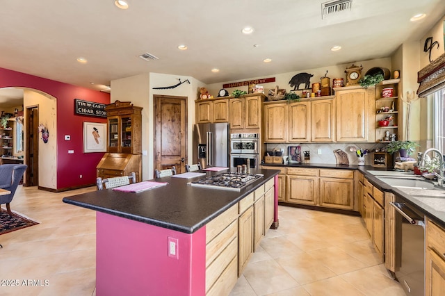kitchen with a sink, visible vents, arched walkways, and appliances with stainless steel finishes