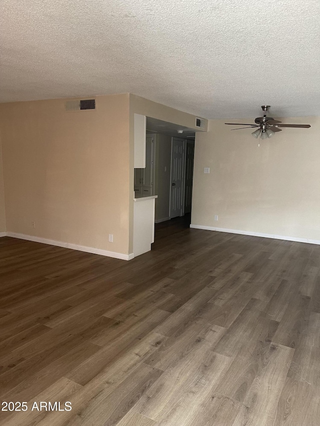 empty room with ceiling fan, a textured ceiling, and dark wood-style flooring