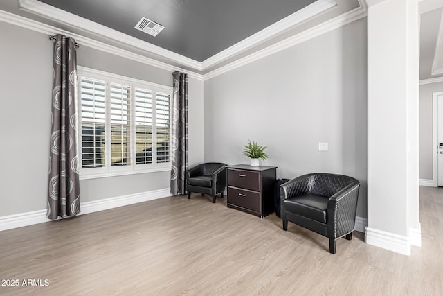 sitting room featuring visible vents, wood finished floors, baseboards, and ornamental molding