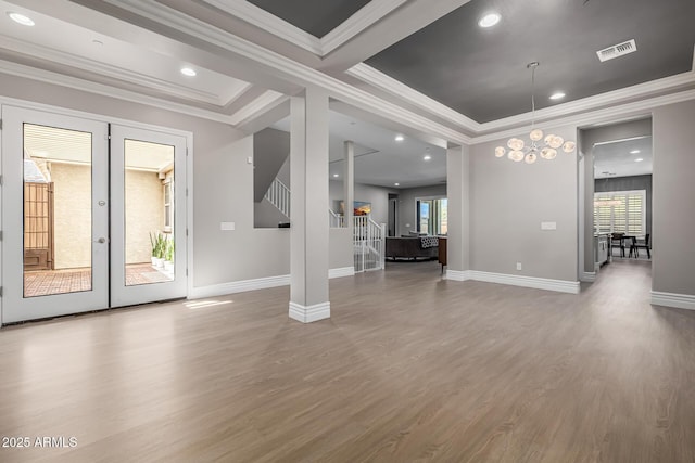 unfurnished living room featuring visible vents, baseboards, wood finished floors, and stairs