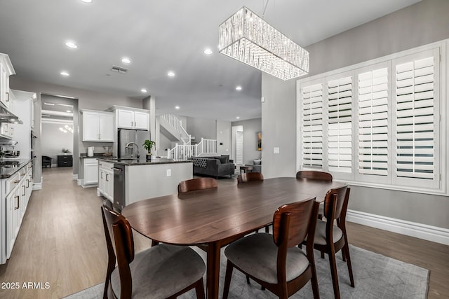 dining area featuring visible vents, baseboards, stairs, recessed lighting, and light wood-style flooring