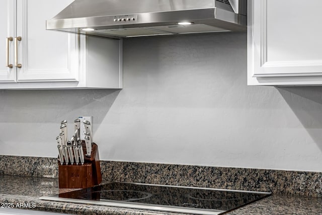 kitchen with black electric stovetop, dark countertops, range hood, and white cabinets