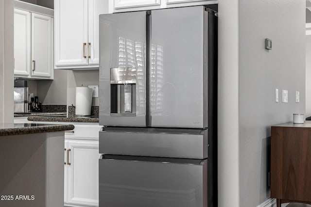 kitchen featuring white cabinetry, dark stone countertops, and stainless steel fridge with ice dispenser