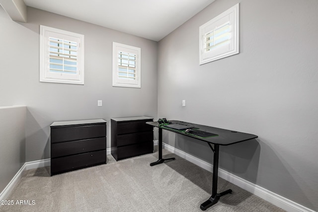 home office with baseboards and light carpet