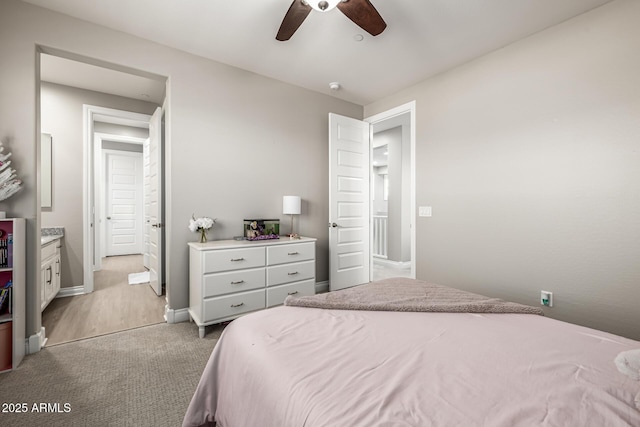 bedroom featuring baseboards, light colored carpet, and a ceiling fan