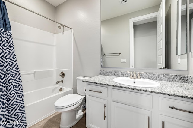bathroom featuring vanity, wood finished floors, visible vents, shower / bath combination with curtain, and toilet