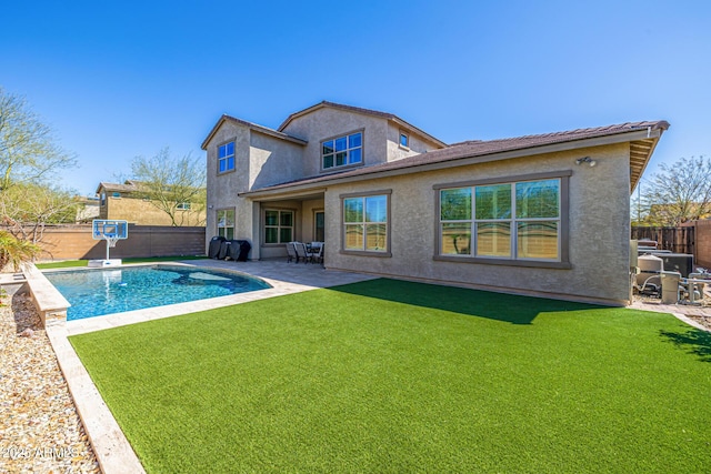 rear view of property with a fenced in pool, stucco siding, a yard, a fenced backyard, and a patio