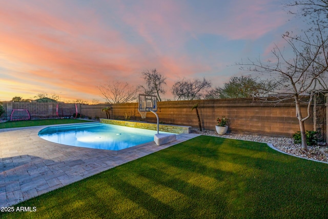 view of pool featuring a patio area, a fenced in pool, a fenced backyard, and a lawn