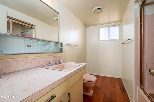 bathroom with hardwood / wood-style floors, vanity, and toilet