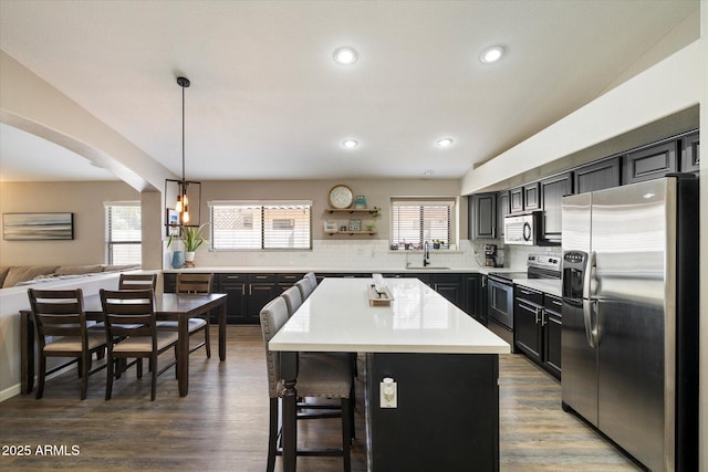 420 S Dodge Dr, Chandler, AZ 85225 - kitchen with appliances with stainless steel finishes, a kitchen breakfast bar, tasteful backsplash, arched walkways, and light countertops