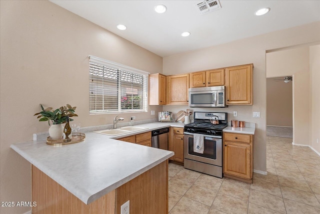 40614 N Key Ln, Anthem, AZ 85086 - kitchen with stainless steel appliances, light countertops, a peninsula, light tile patterned flooring, and recessed lighting