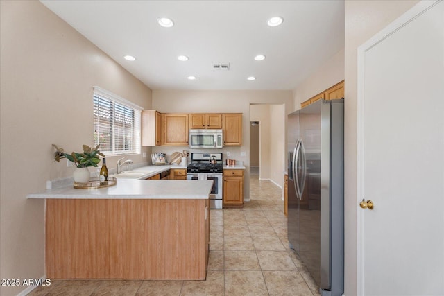 40614 N Key Ln, Anthem, AZ 85086 - kitchen with stainless steel appliances, light countertops, recessed lighting, a peninsula, and light tile patterned floors