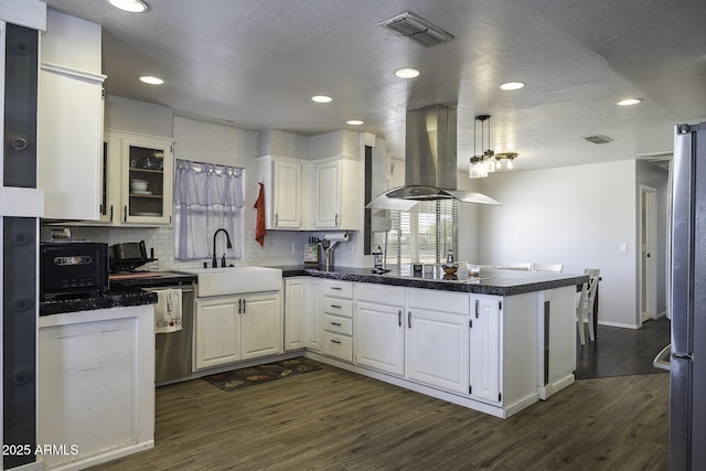 14484 W Jimmie Kerr Blvd, Casa Grande, AZ 85122 - kitchen with island exhaust hood, a peninsula, a sink, dark countertops, and dark wood finished floors