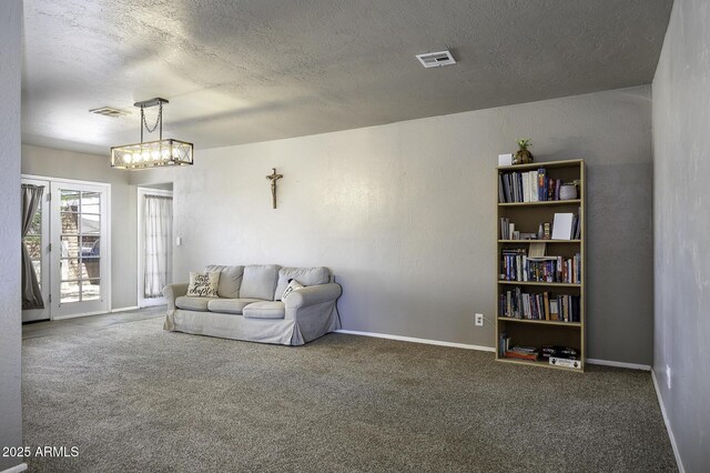14484 W Jimmie Kerr Blvd, Casa Grande, AZ 85122 - carpeted living room featuring a textured ceiling, baseboards, and a chandelier