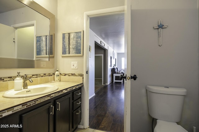 14484 W Jimmie Kerr Blvd, Casa Grande, AZ 85122 - bathroom featuring wood finished floors, toilet, vanity, and decorative backsplash