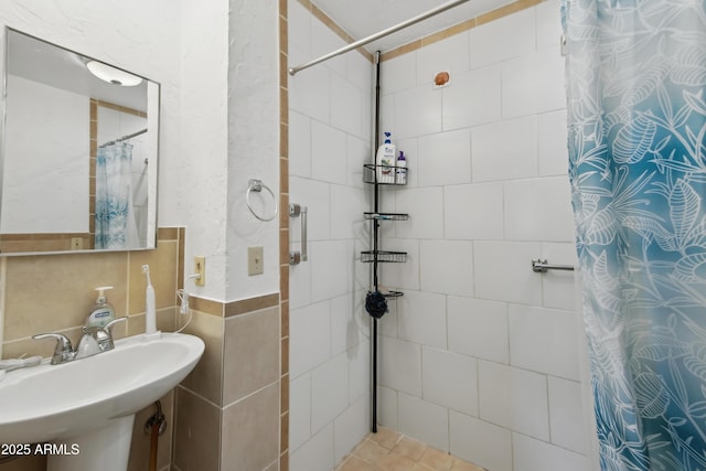 bathroom featuring sink, tile walls, and a shower with shower curtain