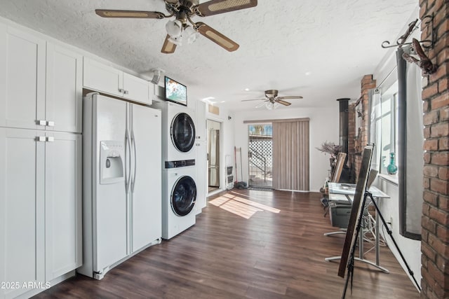 washroom with ceiling fan, stacked washer / dryer, dark hardwood / wood-style flooring, and a textured ceiling