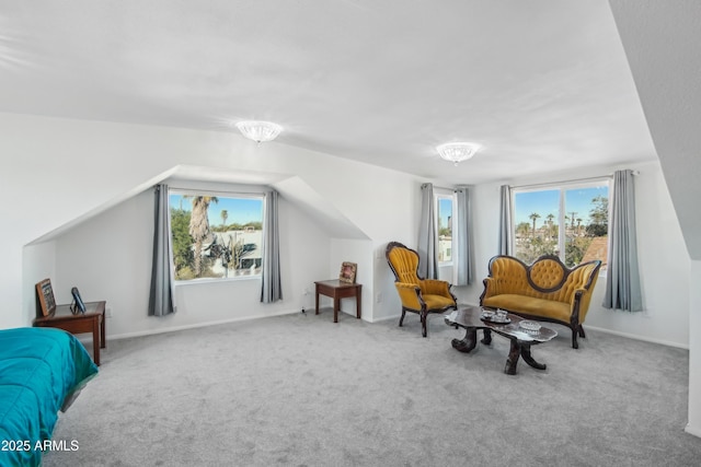 sitting room with carpet floors, plenty of natural light, and vaulted ceiling