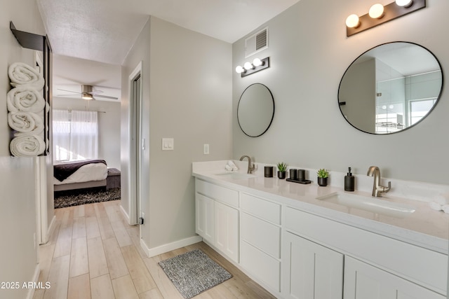 bathroom featuring ceiling fan, a textured ceiling, hardwood / wood-style flooring, and vanity