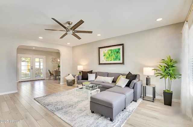 living room featuring ceiling fan, french doors, and light hardwood / wood-style flooring